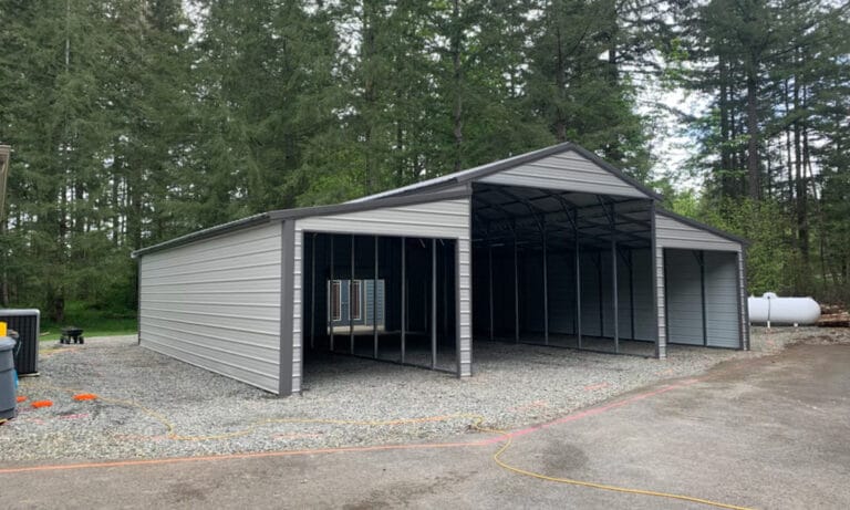 Gray metal carport in forest setting.