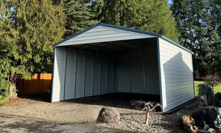 Metal carport in a wooded backyard setting.