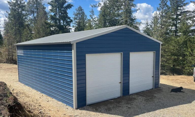 Blue metal garage with forest background.