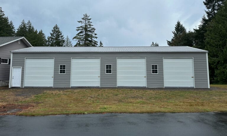 Large gray metal garage with white roll-up doors