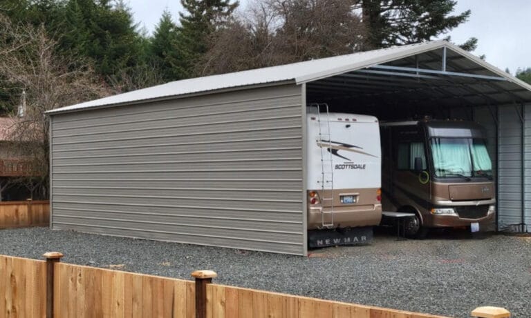 Two RVs parked in a large metal carport.